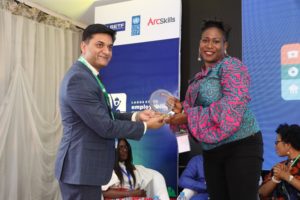 Amit Washington, the CEO of Arc Skills presenting the plaque to Sola Babatunde as one of the panelist after the Apparel Panel discussion. 