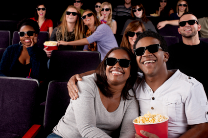 A waist up image of a black couple and a diverse group of people watching a 3D comedy in a movie theater. latasha, byron, thomas, kelly, camry, lilly, ashleigh, tristyn, mary jo, olivia, anna, jessica, kencey, kolika